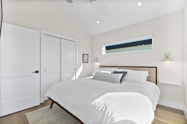 bedroom featuring hardwood / wood-style floors, ceiling fan, lofted ceiling, and a closet