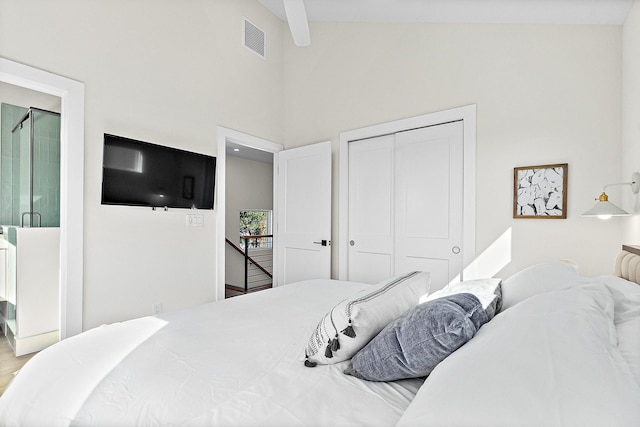 bedroom featuring beamed ceiling, high vaulted ceiling, and a closet