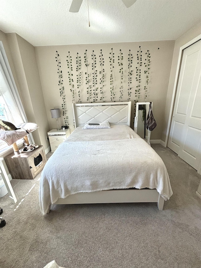 carpeted bedroom featuring a textured ceiling, a closet, and ceiling fan