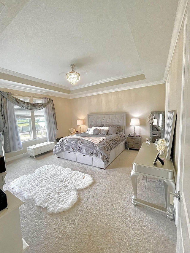 bedroom featuring a tray ceiling, ceiling fan, carpet, and ornamental molding