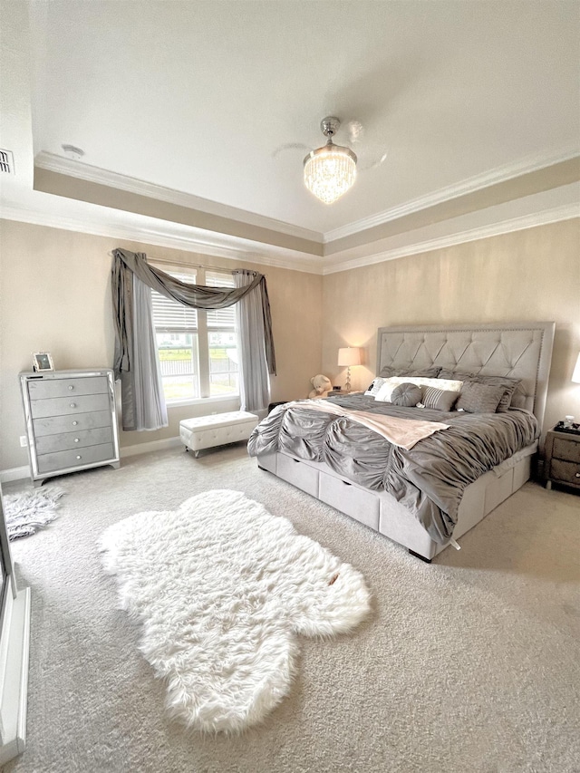 bedroom with a tray ceiling, carpet floors, a notable chandelier, and ornamental molding