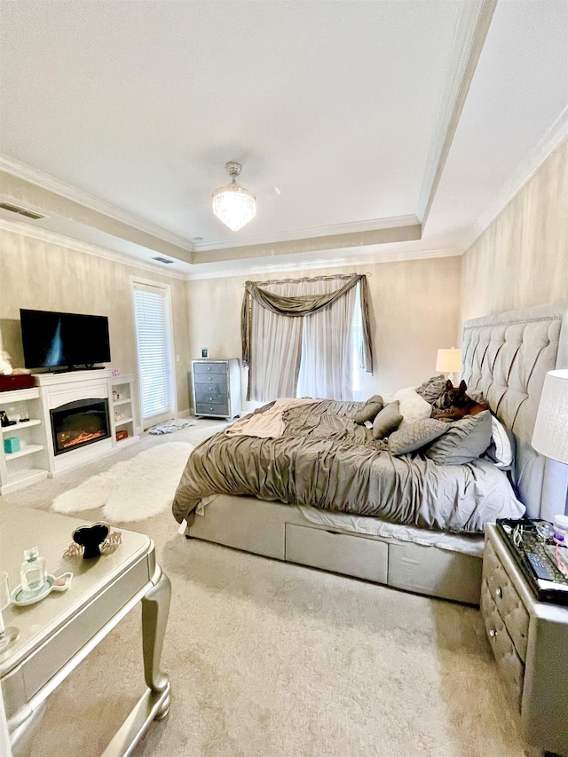 bedroom with a tray ceiling, ceiling fan, carpet, and ornamental molding