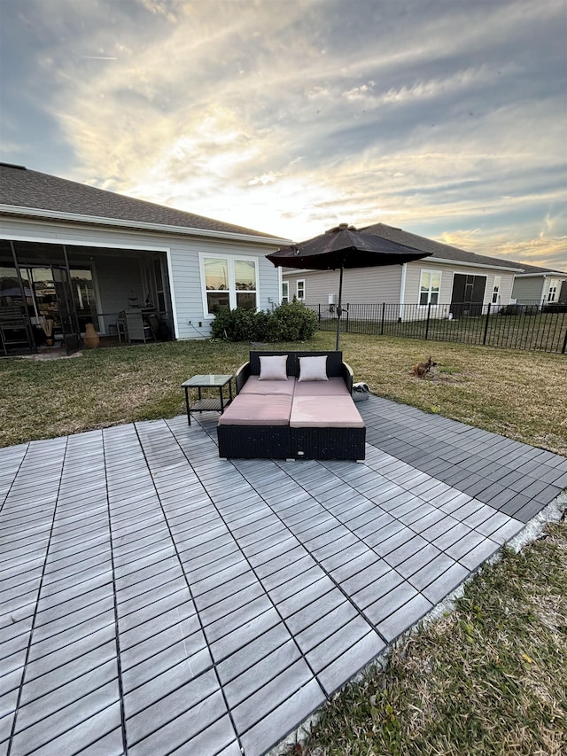 patio terrace at dusk featuring a yard