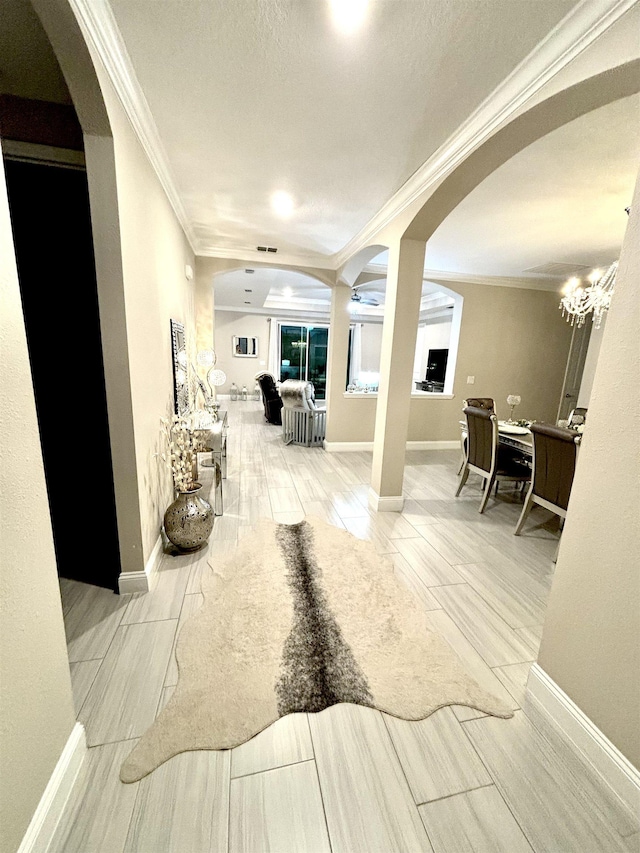 hall with a notable chandelier, wood-type flooring, and crown molding