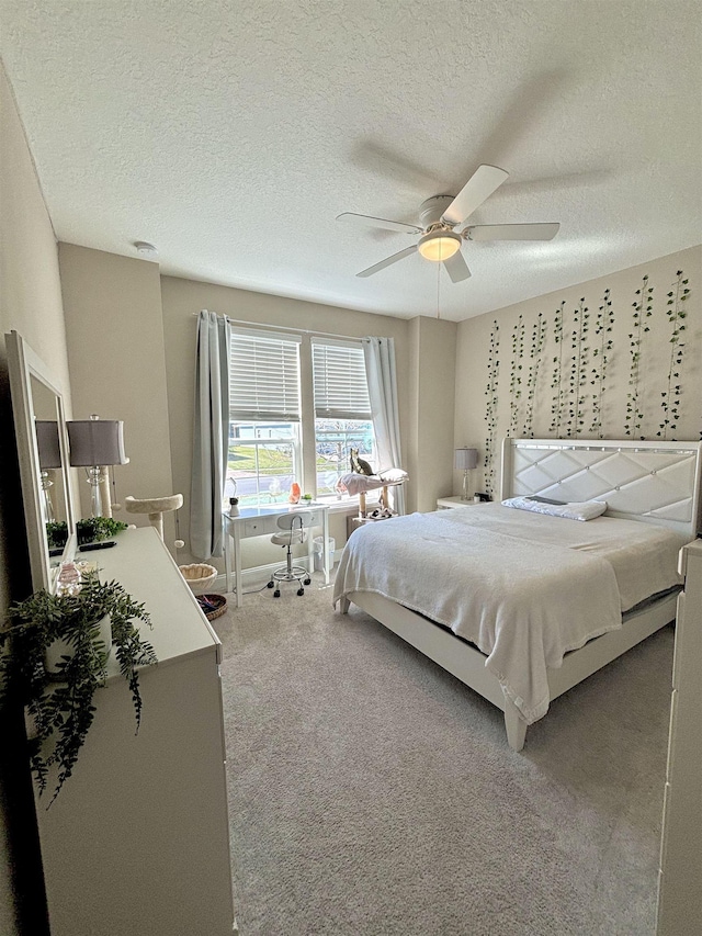 carpeted bedroom with ceiling fan and a textured ceiling