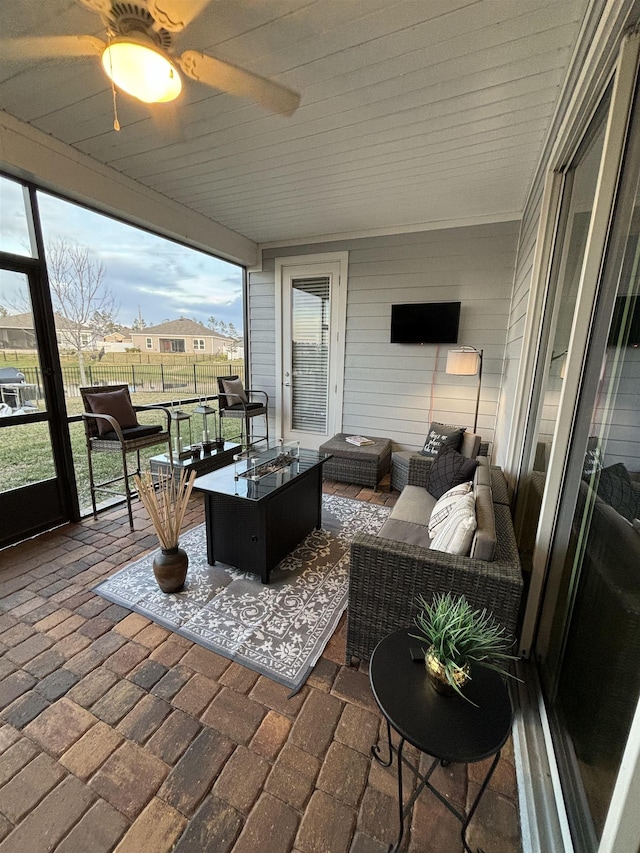 sunroom with ceiling fan and wood ceiling