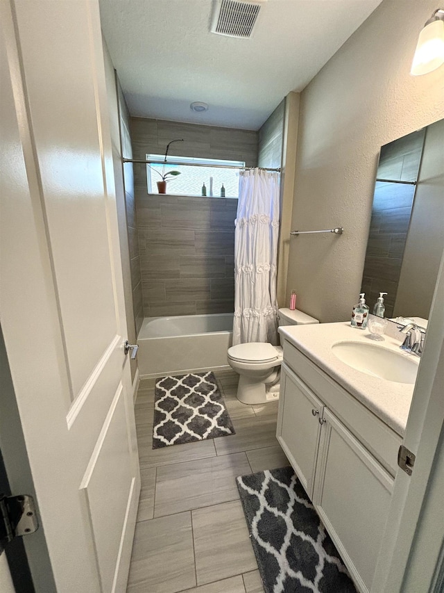 full bathroom featuring vanity, shower / tub combo, and toilet