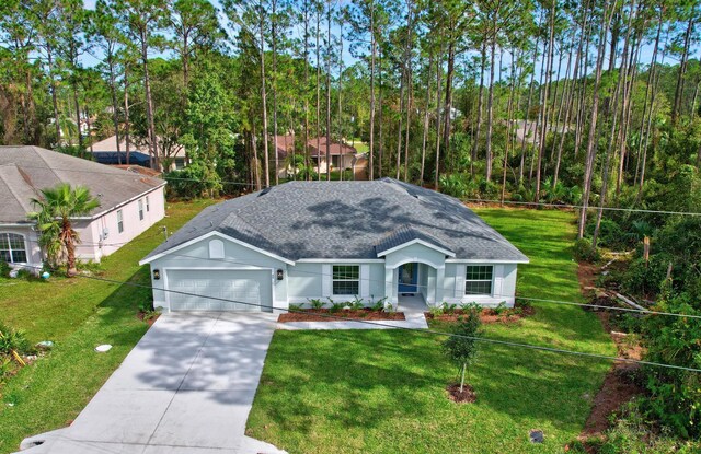 view of front of home with a front lawn and a garage