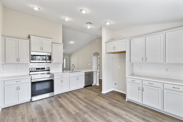 kitchen with sink, white cabinetry, stainless steel appliances, and light wood-type flooring