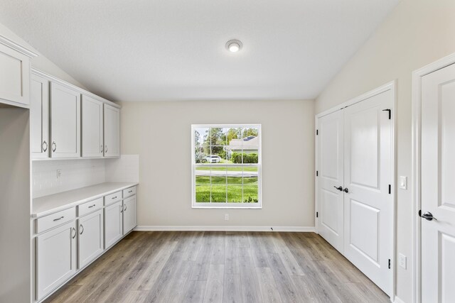 interior space with light hardwood / wood-style flooring and lofted ceiling