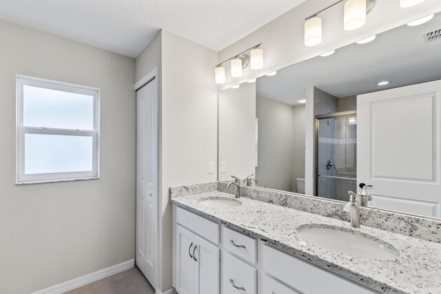 bathroom with vanity, toilet, and an enclosed shower