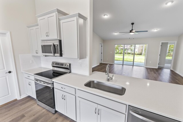 kitchen with sink, white cabinetry, stainless steel appliances, and light wood-type flooring