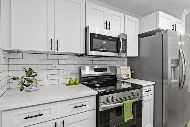 167 Deltona Blvd, Saint Augustine, FL 32086 - kitchen featuring stainless steel appliances, white cabinetry, and light stone countertops
