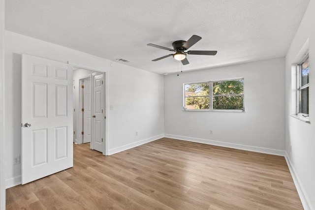167 Deltona Blvd, Saint Augustine, FL 32086 - unfurnished bedroom featuring multiple windows, a textured ceiling, light wood-style floors, baseboards, and ceiling fan