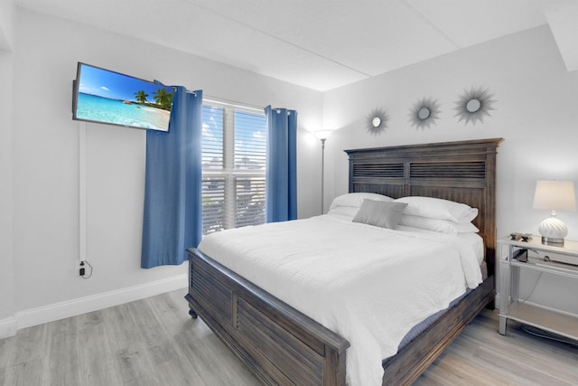 bedroom featuring light wood-style floors and baseboards