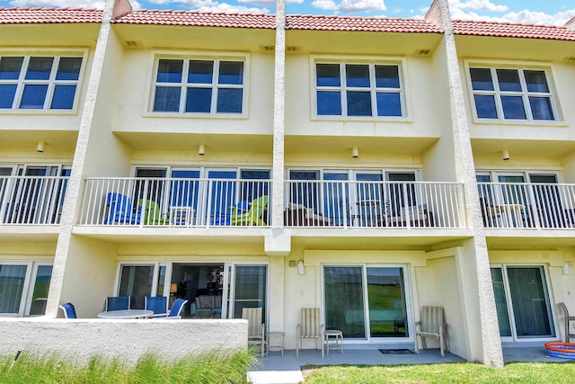 rear view of house featuring stucco siding