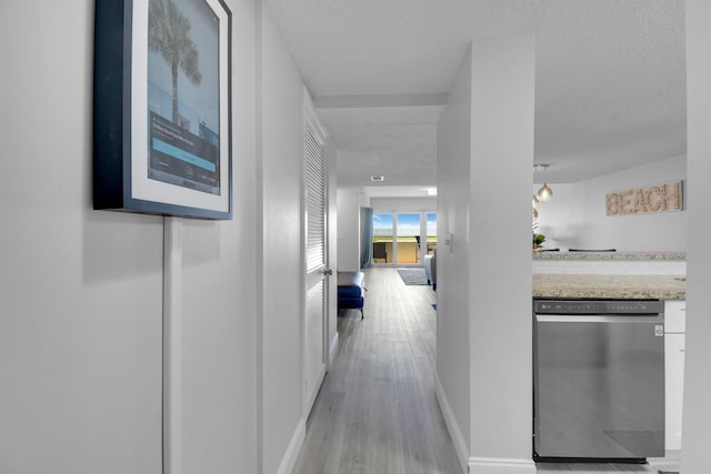 corridor with light wood-style floors and baseboards