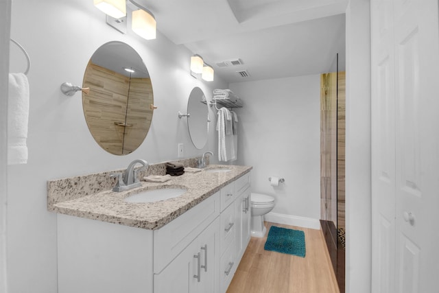 bathroom with visible vents, a sink, toilet, and wood finished floors