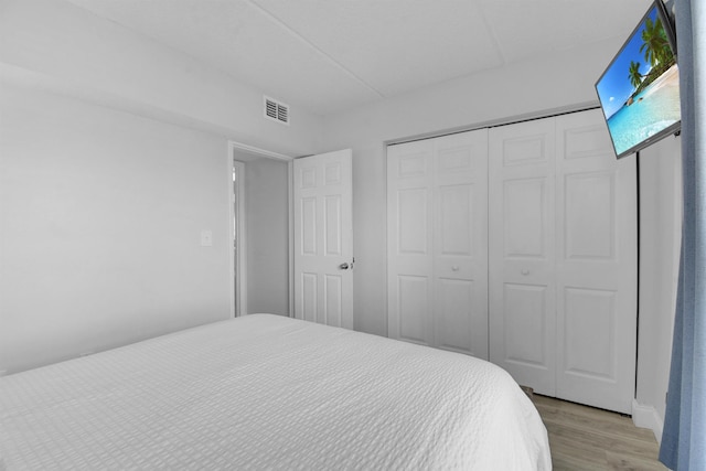 bedroom featuring a closet, visible vents, and light wood-style flooring