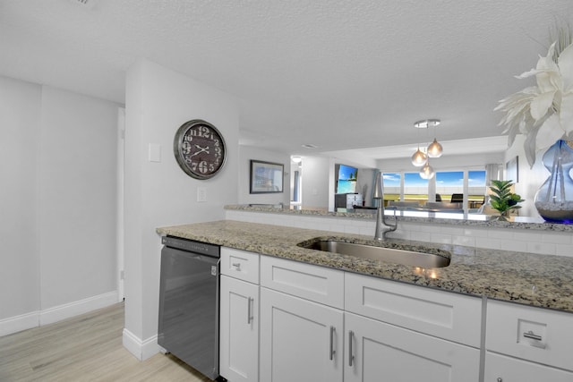 kitchen featuring light stone counters, a sink, white cabinets, light wood-type flooring, and dishwasher