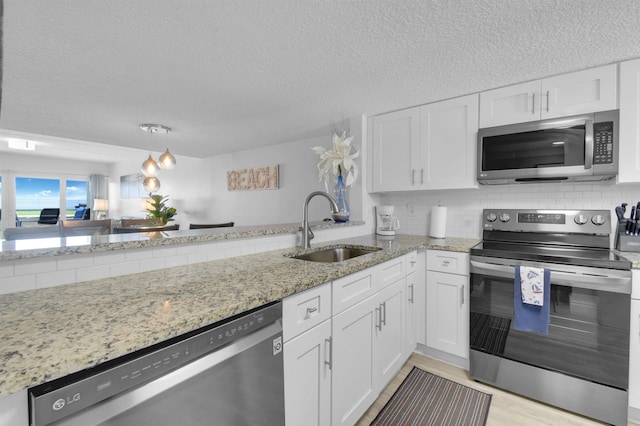 kitchen with decorative backsplash, white cabinetry, stainless steel appliances, and a sink