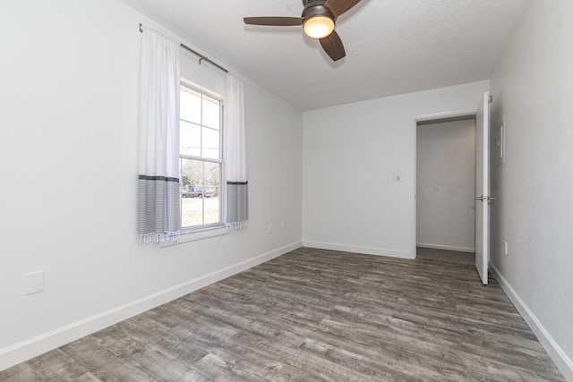 empty room with ceiling fan, wood-type flooring, and a textured ceiling