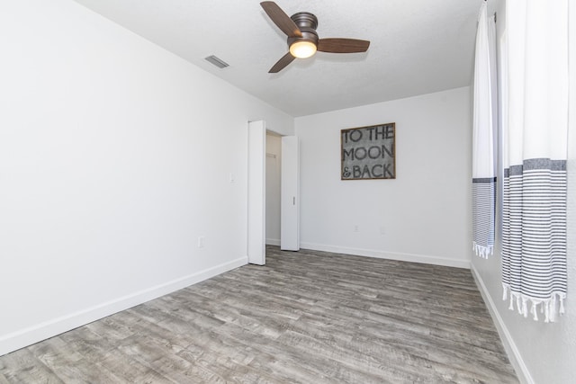 spare room with ceiling fan, light hardwood / wood-style floors, and a textured ceiling