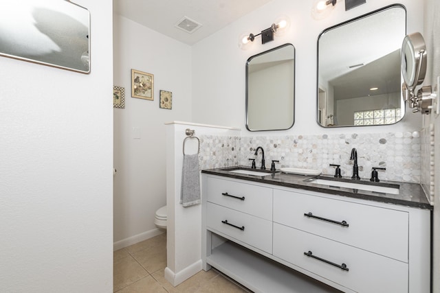 bathroom with tasteful backsplash, vanity, toilet, and tile patterned flooring