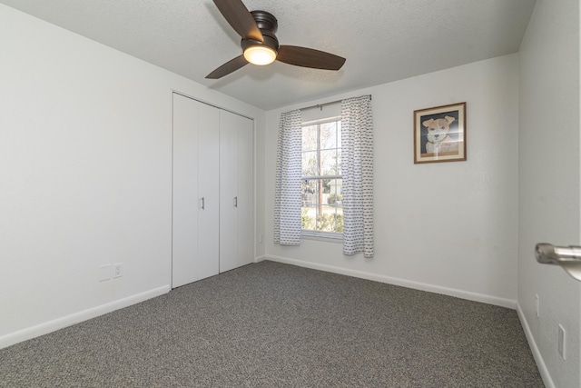 unfurnished bedroom featuring ceiling fan, a closet, a textured ceiling, and carpet flooring