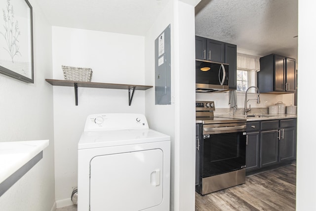 laundry area featuring washer / dryer, sink, dark wood-type flooring, and a textured ceiling