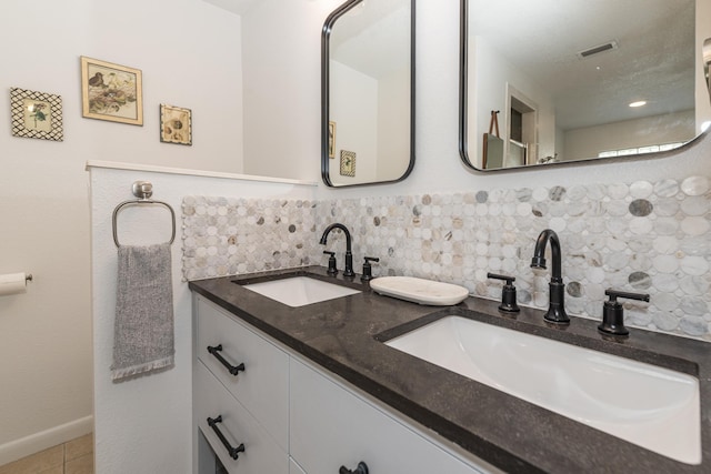 bathroom with tasteful backsplash, vanity, and tile patterned floors