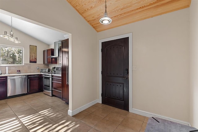 100 Saturn Rd, Saint Augustine, FL 32086 - kitchen featuring appliances with stainless steel finishes, lofted ceiling, wall chimney exhaust hood, light tile patterned floors, and light countertops