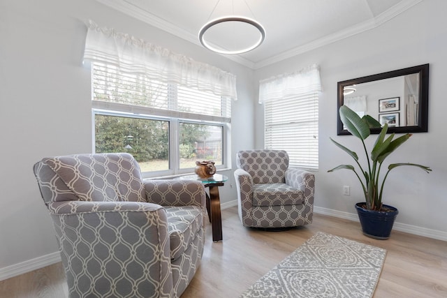 living area with ornamental molding and light hardwood / wood-style floors