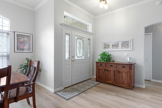 entryway with ornamental molding and light hardwood / wood-style flooring