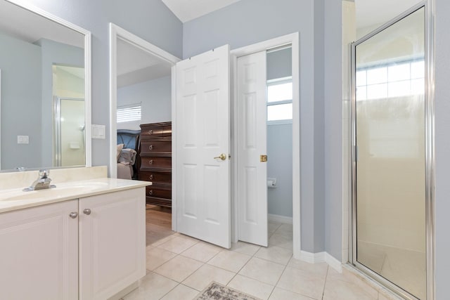 bathroom featuring vanity, a shower with shower door, and tile patterned floors