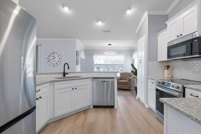 kitchen featuring sink, white cabinets, light hardwood / wood-style floors, stainless steel appliances, and crown molding