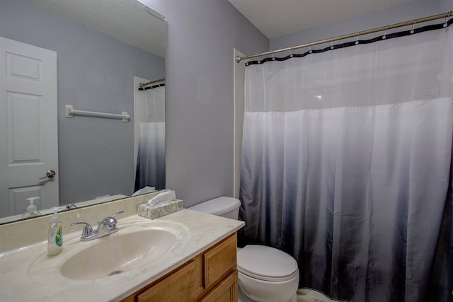 bathroom featuring vanity, toilet, and a textured ceiling