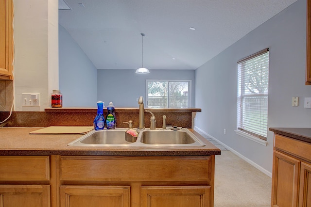 kitchen with pendant lighting, light colored carpet, and sink