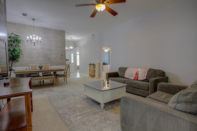 tiled living room featuring ceiling fan with notable chandelier