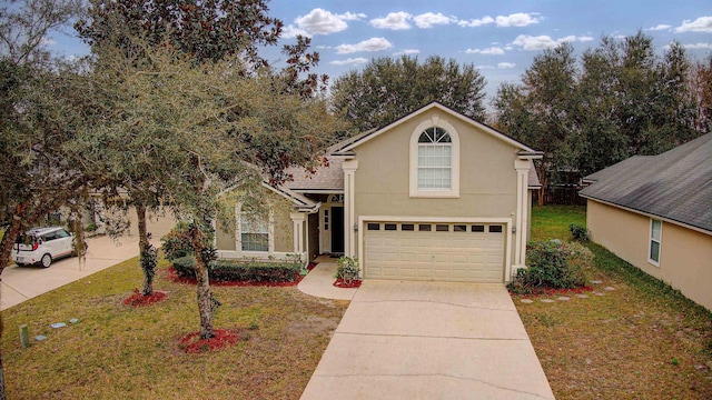 view of property with a garage and a front yard