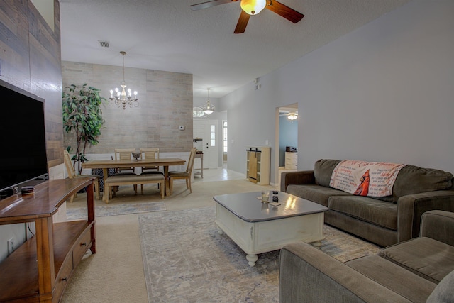 living room with a textured ceiling and ceiling fan with notable chandelier