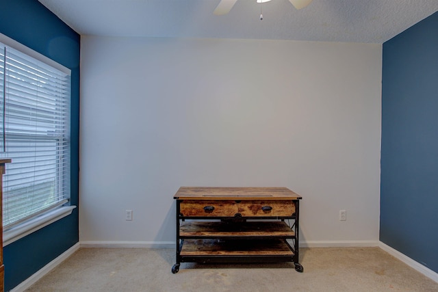 interior space featuring ceiling fan and light colored carpet