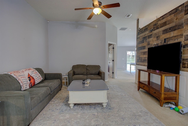 carpeted living room with a textured ceiling and ceiling fan