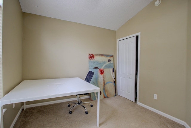 carpeted home office with lofted ceiling