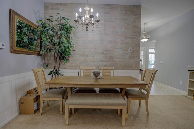 dining area with light carpet and a chandelier