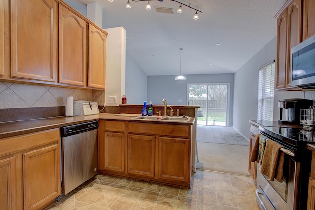 kitchen with kitchen peninsula, decorative backsplash, stainless steel appliances, sink, and hanging light fixtures