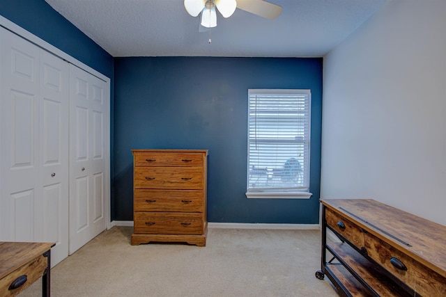 bedroom featuring ceiling fan, a closet, and light colored carpet