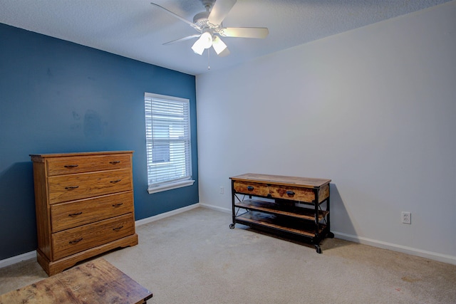 interior space with a textured ceiling, ceiling fan, and light carpet