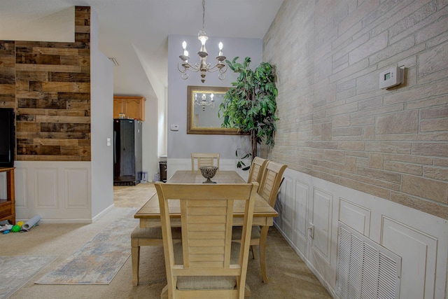 carpeted dining space with a high ceiling and an inviting chandelier