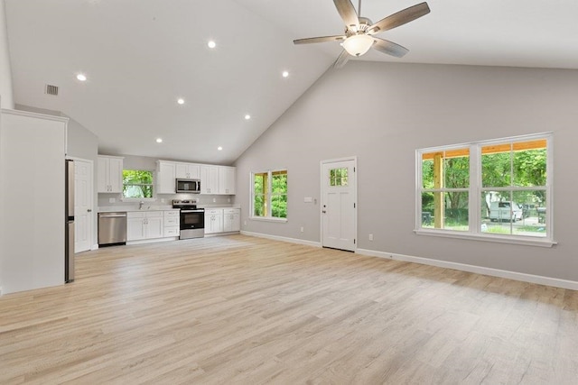 2891 N 8th St, Saint Augustine, FL 32084 - unfurnished living room with high vaulted ceiling, ceiling fan, light wood finished floors, and recessed lighting